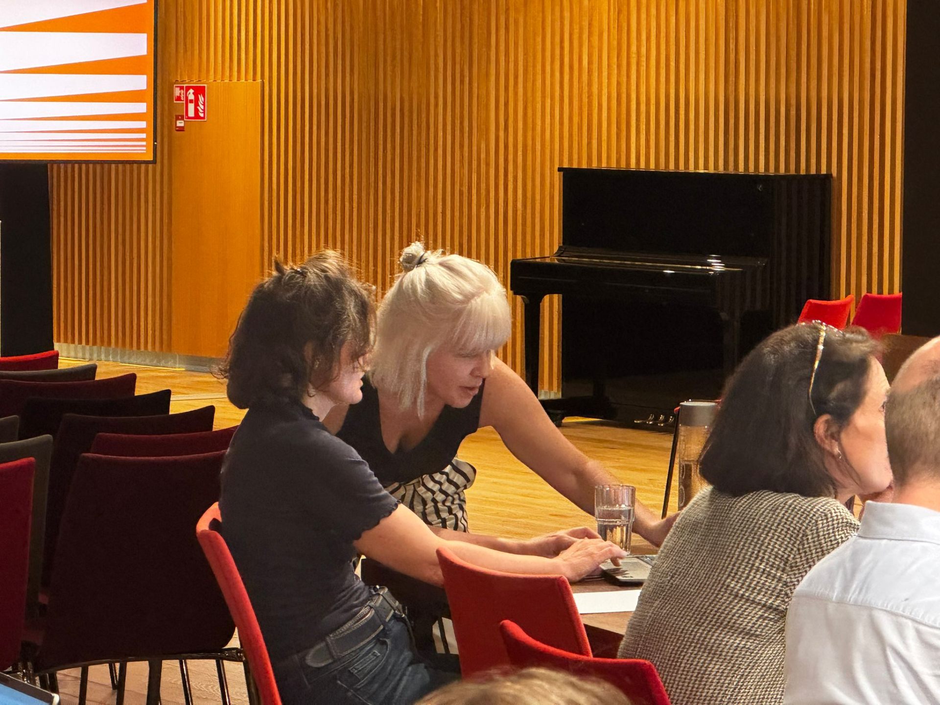 Brooke Gallagher helping a participant at their laptop during a hands-on AI workshop